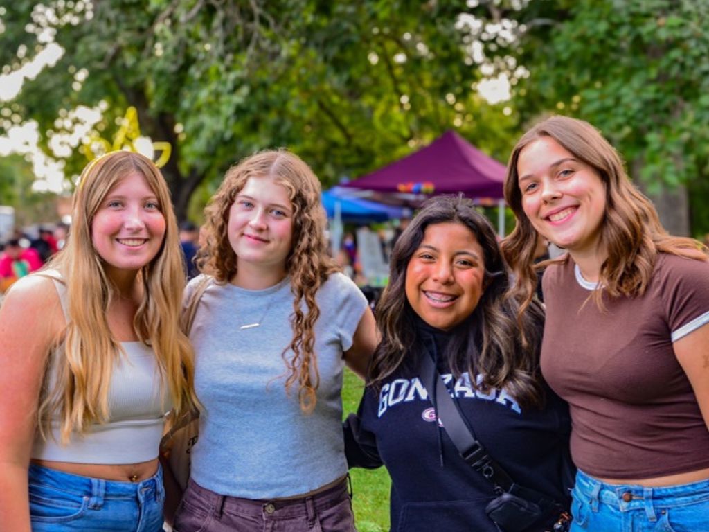 4 college students smiling at the Logan Block Party.